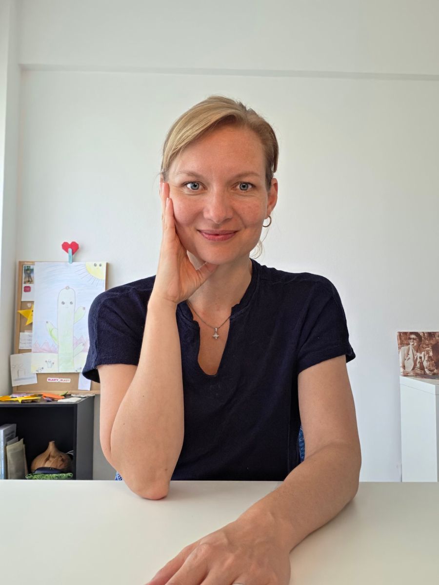 Alena Gomes Rodrigues, founder of Zen Supermom, smiling with her hand on her cheek